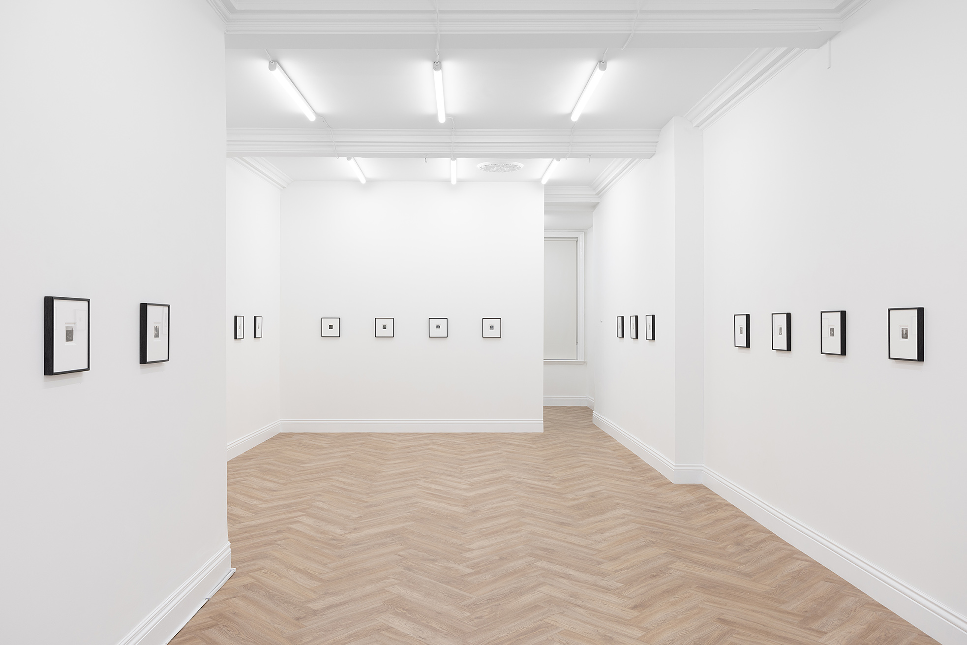 The full view of the gallery space at Huxley-Parlour Gallery's exhibition of Dora Maar's photography at 45 Maddox Street, W1S 2PE. Three white walls with early twentieth-century contact prints hung in black frames.