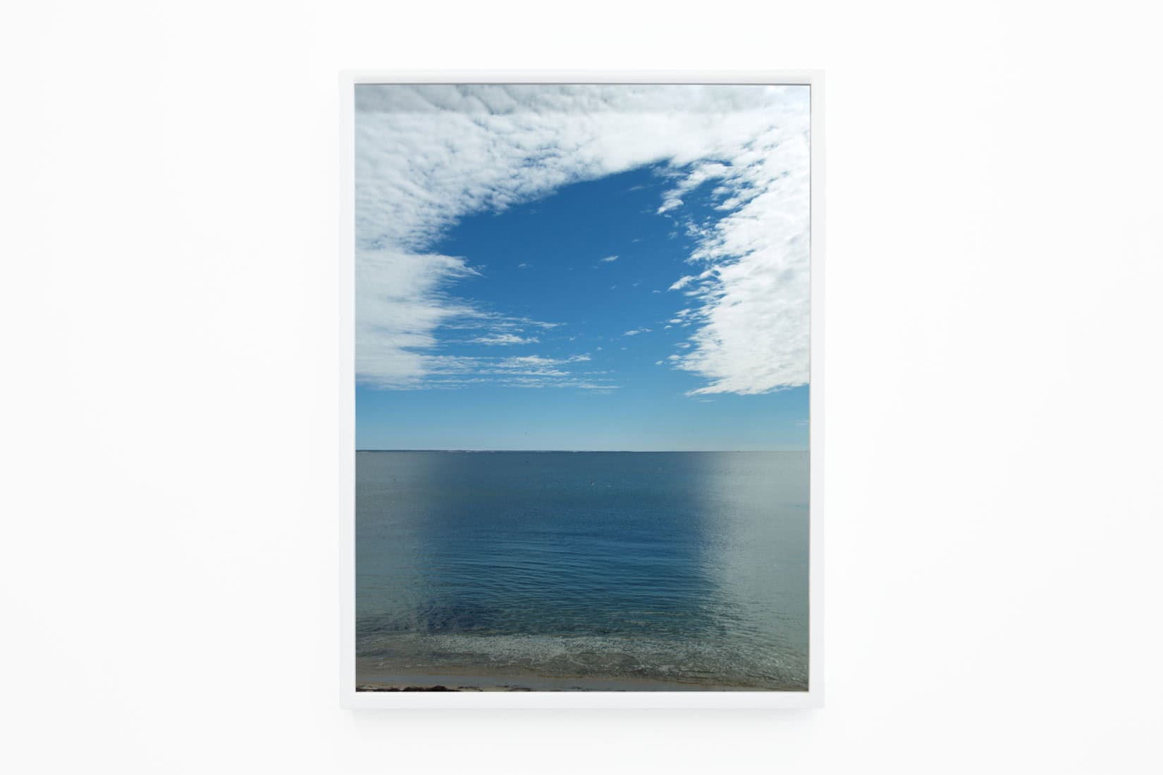 Photo of clouds and blue sky reflected on a sea.