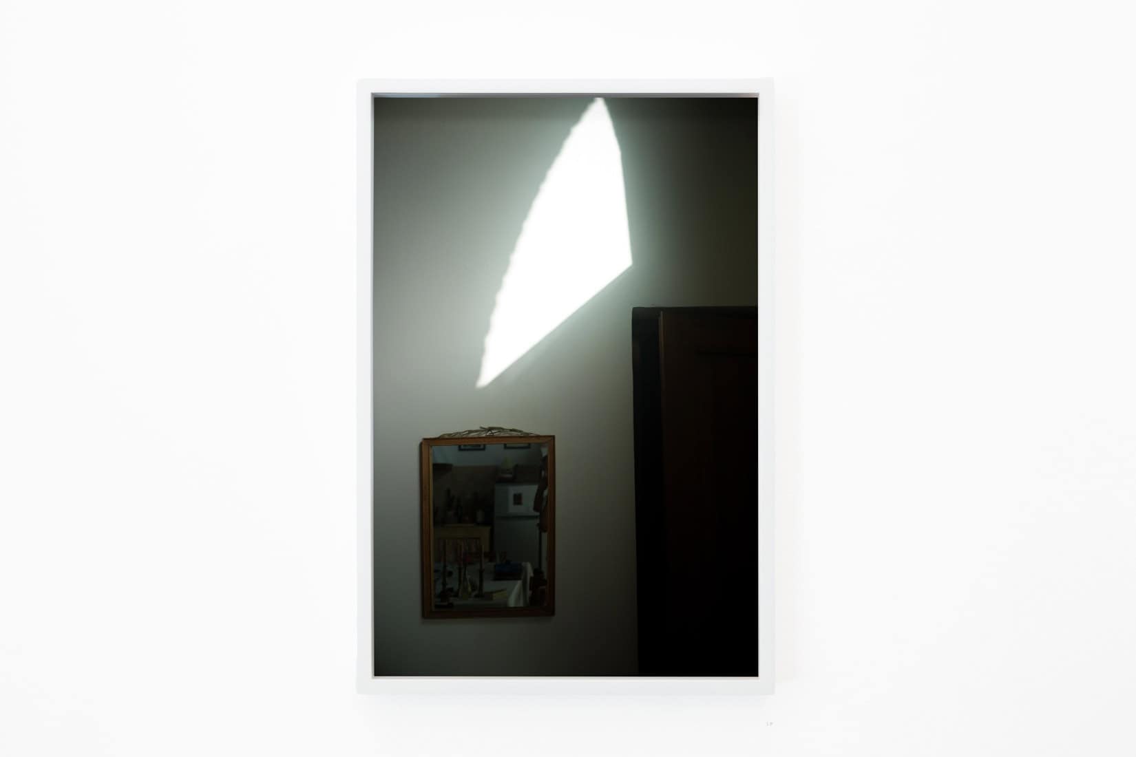 Photo of sunlight on a wall with a mirror.
