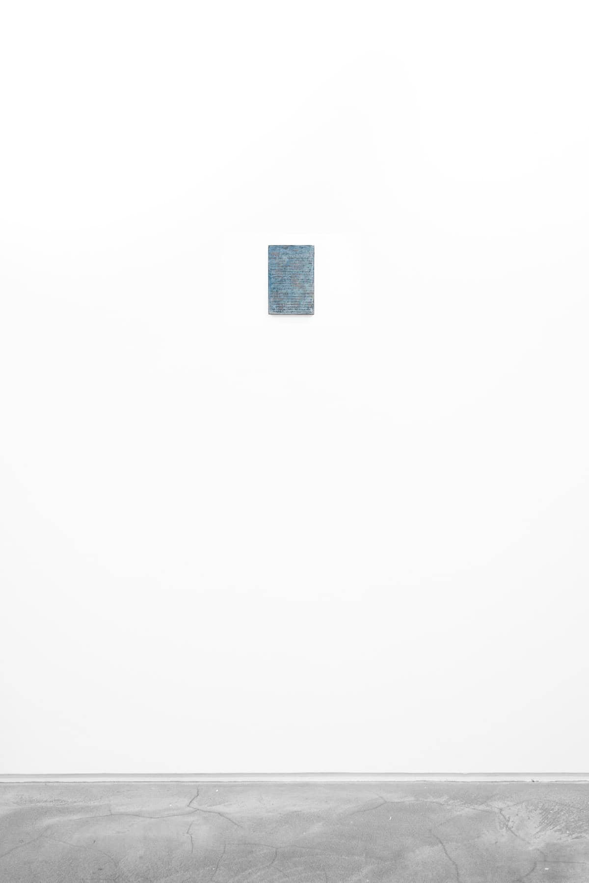 Abstract painting of speckled blue on paper and wood.