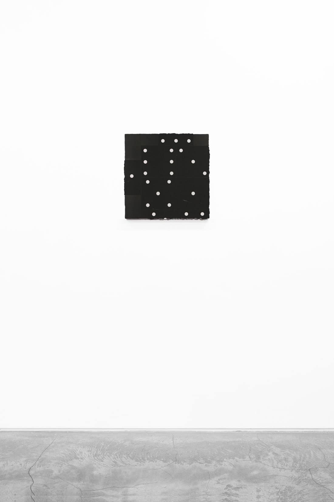An artwork with a black background and white dots.
